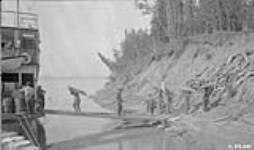 "Wooding up" a familiar scene in river transportation on the Mackenzie. 1925