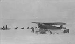 A contrast in modes of Arctic Travel Mat Berry's aeroplane and Dick Finnie's dog team. April 1931