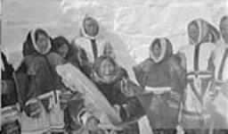 [À droite, Kia Arnauyuk et Ikpuckhuak, et peut-être Jennie Kanneyuk.] Une groupe d'Inuits dans une scène du film "Dance of the Copper Eskimos"
  Avril 1931.