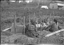 [Indian Women making a canoe at Stanley or Churchill River, Sask.]. [c. 1931]