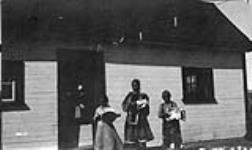 Autochtones de Blacklead recevant des présents envoyés par le Cercle canadien de Montréal, devant l'entrepôt M.O., Pangnirtung (T.N.-O.) 1936.