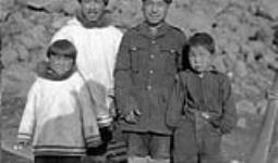 Gendarmes spéciaux de la Gendarmerie royale du Canada (GRC) avec des enfants. [De gauche à droite : Uvvatuattiaq, Mala, Aluluuq Aksakattak et Aula. Ils étaient des employés de la Gendarmerie royale du Canada (GRC).]. 6 Septembre 1936