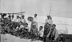 Gwichya Gwich'in men and boys playing Dene Handgame while a man plays a drum  1930