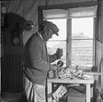 George Weetaltuk uses modern tools when carving ivory. 1949