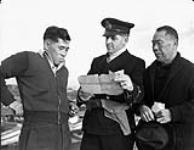 Officier de la Marine royale du Canada (MRC) en train d'interroger un pêcheur canadien d'origine japonaise et de confisquer son bateau 9 déc. 1941