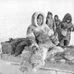 [Left to right: Sapangaarjuk, Apak? 3rd individual unidentified, and Lazarus Uttak? Sapangaarjuk, Hannah Uyarak's father, was returning to Igloolik from Hall Beach and froze his feet, which had to be amputated.]. n.d.