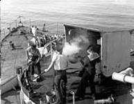 Naval ratings firing a three-inch gun aboard a Bangor-class minesweeper of the Royal Canadian Navy (R.C.N.) during working-up exercises off Pictou, Nova Scotia, Canada, 1943. 1943.
