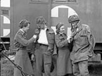 Nursing sisters of Princess Mary's Royal Air Force Nursing Service talking with wounded soldiers, Beny-sur-Mer, France, 16 June 1944. June 16, 1944.