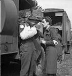 Pte. F. Madore with Nursing Sister M.F. Giles waiting for an air-evacuation from an R.C.A.F. Spitfire base, Normandy, France, 16 June 1944. June 16, 1944.