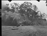 Burning trucks belonging to Canadian troops who were bombed by Americans. 8 Aug. 1944