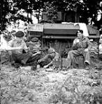 Sgt. A. Dunn, Tpr. Eddy Bishop, L/Cpl. Ken McLeod and Tpr. Bill Wallace having lunch around thier tank. 08-Jul-44