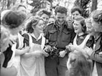 Rifleman R.M. Douglas of The Royal Winnipeg Rifles with a group of Dutch women who are celebrating the liberation of Deventer, Netherlands, 10 April 1945 Apri1 10, 1945.