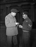Lieutenant-Colonel J.F.R. Akehurst, Commanding Officer, 2nd Battalion, First Special Service Force, examines Sergeant Tommy Prince's Military Medal, which was awarded for "distinguished and gallant service" at Anzio. Buckingham Palace, London, England, 12 February 1945  February 12, 1945.