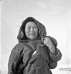 Inuit woman wearing caribou or duffle parka and living in the area between Provungnituk and Poste-de-la-Baleine. Jan. 1946.