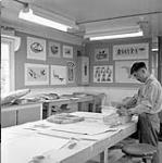 Luktak, Inuit artist, working in the art centre, Cape Dorset, N.W.T., [Cape Dorset (Kinngait), Nunavut], August 1961. August 1961.