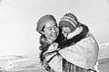 Une jeune femme inuite portant un enfant dans son amauti vers 1947 - 1948.
