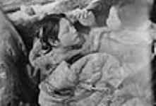 Femme et enfant inuits allongés. [Helen Konek (à gauche) et Kinalik à droite).] 1949-1950