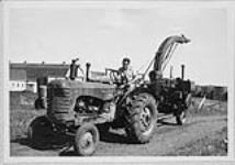 Mr. Eric Jarvis with Massey Harris  tractor and forage harvester. c.a.1959