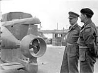 Brigadier J.A. Roberts of the 8th Canadian Infantry Brigade and Major-General Harry W. Foster, General Officer Commanding 1st Canadian Infantry Division, examining a small German submarine, IJmuiden, Netherlands, 25 May 1945. May 25, 1945.