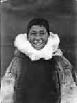 Un garçon Inuit porte un vêtement de fourrure. [Garçon inconnu vêtu d'un parka en peau de caribou porté pour les photographies.]. Août 1931.