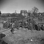 Personnel of the Royal Canadian Engineers building a pontoon bridge across the Dortmund-Ems Canal. 8 Apr. 1945