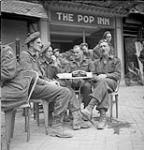 Soldiers at the new Navy, Army and Air Force Institute (N.A.A.F.I) canteen 'The Pop Inn'. L. to .r: Sgts. Harry Froats and Herb Bowen, Cpl. John Hay and Sgt. Andrew Hummell. 27-Jul-44