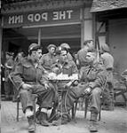 Soldiers at the new Navy, Army and Air Force Institute (N.A.A.F.I) canteen 'The Pop Inn'. L. to .r: Driver Henry Burman, Ptes. Ray Caze and Vic Robinson. 27-Jul-44