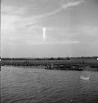Engineers towing Bailey bridge sections up the Orne River to build another bridge. 18-Jul-44