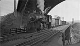 Toronto, Hamilton & Buffalo Railway - Locomotive # 106 under High Level Bridge - left view with C.P.R. (Canadian Pacific Railway) freight train. 28 June 1947