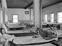 Two Cree girls in their beds in the girls' dormitory at All Saints Indian Residential School, Lac La Ronge, Saskatchewan, March 1945  March 1945.