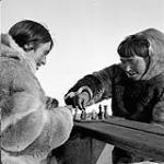 Two Inuit men playing chess. 1953
