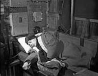 An off-watch officer asleep aboard H.M.C.S. OAKVILLE at sea, 23 March 1942. March 23, 1942