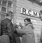 [Panikpakuttuk (au centre) et Qajaaq (à droite). L'homme à gauche est inconnu. Ils travaillaient pour le détachement de la Gendarmerie royale du Canada (GRC).]. Juillet 1951