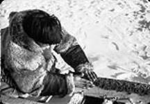 Inuit man preparing komatik runners.  1926-1943.
