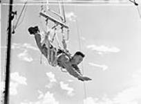 Le caporal N.R.V. Chapman, un membre du premier groupe de candidats à l'école de parachutisme, s'entraîne avec le harnais antichoc à l'École d'entraînement au parachutisme de l'Armée américaine vers le 1er au 6 septembre 1943.