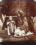 Ojibwa woman with child in carrier basket. 1858