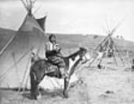 Portrait of Kitsipimi Otunna, a Sarcee woman on horseback. ca. 1903-1936