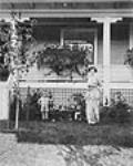Nellie L. McClung, her son Mark and dog Philip in the front yard of her house at 11229 - 100 Avenue. ca. 1910