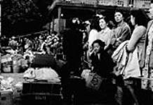 Groupe d'immigrants japonais qui ont été internés lors de la Deuxième Guerre mondiale, attendant un train qui les emmènera à des navires en partance pour le Japon, 1946 1946