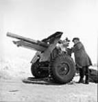 Workman fires a 25-pounder gun at the Valcartier test ranges. Feb. 1943