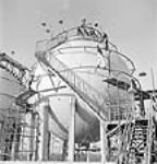 Dans la cour de l'usine Société Polymer Limitée, vue d'un réservoir de stockage Horton. oct. 1943