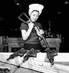 Female Chinese-Canadian worker Agnes Wong of Whitecourt, Alberta, assembles a sten gun produced for China by the Small Arms Ltd. plant. Apr. 1944