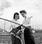 Des ouvrières de l'usine Cherrier ou Bouchard de la Defence Industries Limited tirent à l'arc. juin 1944