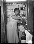 Singer Velma Middleton in the Berens' kitchen cupboard.  Middleton first sang at the Standish Hall Hotel with Louis Armstrong in 1949; the two returned to Hull a number of times.  Their last performance together in the community was in 1960, at the Hull arena. ca. 1950.