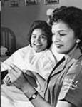 [The practical nursing course at the Vancouver Vocational Institute is popular with Indian girls like Elizabeth Jonathan, Whitehorse, Y.T., (left) acting as patient, and Violet Harry, of Courtenay. Indian students at the Vocational Institute increased in number from eight in 1954 to approximately 60 in 1959.] June 20, 1959