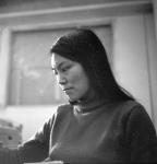 Side view of a woman looking down at an unidentified object [Betty Natsialuk (nee Amarouk) Hughson, Baker Lake (Qamanittuaq), Nunavut]  1969.