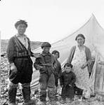 Inuit family [Thomas Siatalaaq, Maurice Alikutiaq, Simone Alikaswa, Max Okatsiak, Arnalaaq] in front of tent  1948
