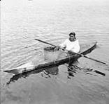 Inuk man in a kayak at Port Harrison [Inukjuak]. 1949