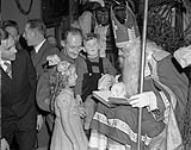 Breda - Sgt. Major Fred Jolley of Guelph, Ontario talks to Santa Claus with a little Dutch boy and girl. December 6, 1944.
