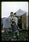 Artiste Kenojuak et ses deux enfants sortant une tente à Cape Dorset, Nunavut [entre le 24 août-le 3 octobre 1960].